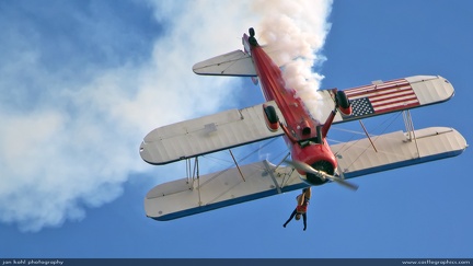 Riding the Wind -- Wingwalker strikes a pose on a gyrating biplane